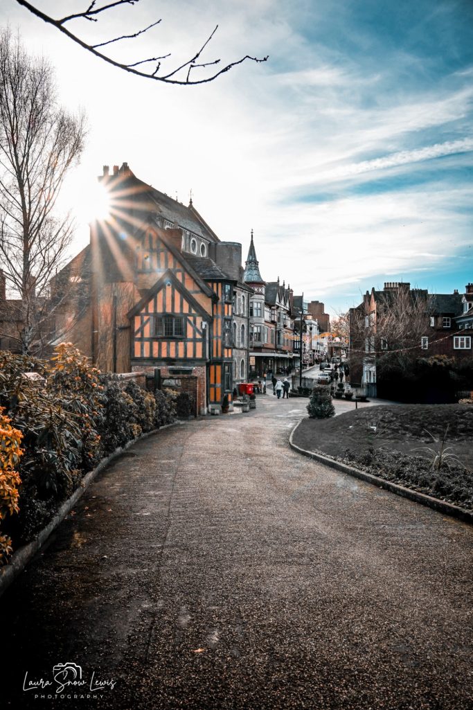 A winding pathway leads to a historic building under a sunny sky.