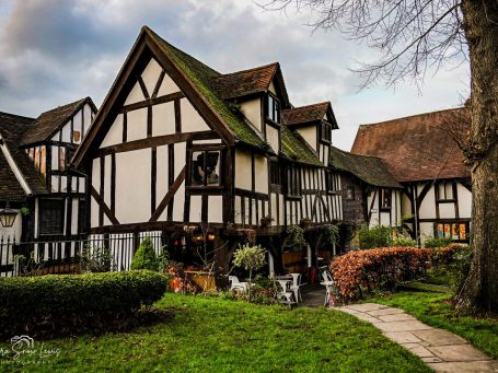 Quaint Tudor-style house with timber framing and a well-kept garden path.