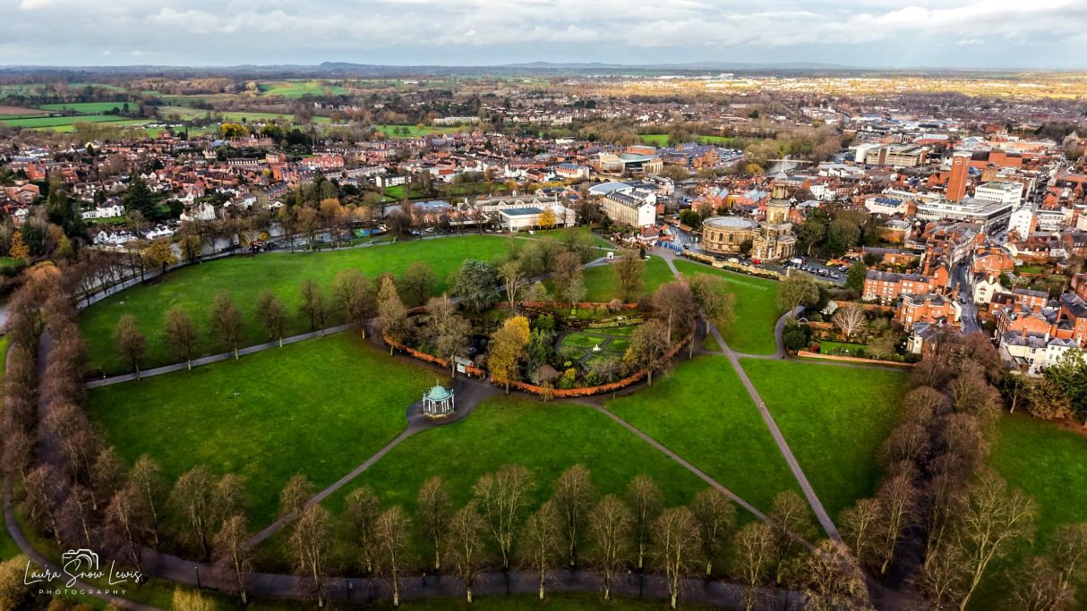 Aerial view of a circular park surrounded by trees and residential areas.